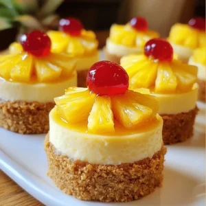 - 1 cup graham cracker crumbs - ¼ cup unsalted butter, melted - 2 tablespoons granulated sugar - 1 cup cream cheese, softened to room temperature - ½ cup granulated sugar - 1 teaspoon pure vanilla extract - 2 large eggs, at room temperature - ½ cup crushed pineapple, thoroughly drained - ¼ cup pineapple chunks, for topping - Maraschino cherries, for garnish - 1 cup = 8 fluid ounces - ¼ cup = 2 fluid ounces - 2 tablespoons = 1 fluid ounce - 1 teaspoon = 4.9 milliliters - Choosing the right cream cheese: Look for cream cheese that is smooth and creamy. Check the expiration date. The fresher the cheese, the better your cheesecake will taste. - Selecting ripe pineapples: Choose pineapples that smell sweet at the base. The skin should be firm but give slightly when pressed. A ripe pineapple will feel heavy for its size and have a vibrant color. This section gives you essential details about the ingredients in your mini pineapple upside-down cheesecakes. You can find the full recipe above for specific measurements and instructions! - Preheating the oven: Start by preheating your oven to 325°F (160°C). This step helps bake the cheesecakes evenly. - Preparing the crust: In a medium bowl, mix 1 cup of graham cracker crumbs, ¼ cup of melted unsalted butter, and 2 tablespoons of granulated sugar. Stir until it looks like wet sand. Press about 1 tablespoon of this mix into the bottom of each muffin cup. This will create a strong base for your mini cheesecakes. - Mixing cream cheese and sugar: Use a large mixing bowl to beat 1 cup of softened cream cheese until it’s smooth. Gradually add ½ cup of granulated sugar and 1 teaspoon of pure vanilla extract. Mix until it’s creamy and well blended. - Adding eggs and folding in pineapple: Add 2 large eggs one at a time. Mix on low speed after each egg until just blended. Be careful not to overmix. Next, gently fold in ½ cup of thoroughly drained crushed pineapple. This gives your cheesecake a fruity twist. - Filling the cups and topping with pineapple: Carefully spoon the cheesecake batter over the prepared crusts. Fill each cup about ¾ full. Leave some space for the cheesecakes to rise. Then, add a few chunks of pineapple on top of the batter. - Baking time and tips for checking doneness: Place the cheesecake pan into the oven and bake for 18-20 minutes. Look for slightly set edges and a jiggly center. The slight jiggle means a creamy texture. After baking, let the cheesecakes cool for 30 minutes. Then, refrigerate them for at least 2 hours before serving. This step allows the flavors to blend and the texture to firm up. For more detailed steps, check the Full Recipe. To make light and fluffy cheesecakes, avoid overmixing the batter. Mix just until smooth, especially after adding eggs. This keeps air in the mixture, making your cheesecakes soft. Cooling is key. After baking, let the cheesecakes cool at room temperature for 30 minutes. Then, chill them in the fridge for at least 2 hours. This helps the flavors blend and the texture to firm up nicely. For a beautiful presentation, serve your mini cheesecakes on a decorative plate or a cake stand. You can add a mint leaf beside each one for a fresh touch. A maraschino cherry on top adds color and sweetness. Pair these cheesecakes with drinks like iced tea or a fruity soda. They also go well with coffee, enhancing the sweet and tangy flavors. Use a mini cheesecake pan or muffin tin for the best results. Silicone baking cups are great, too. They help you pop the cheesecakes out easily. Essential kitchen tools include a mixing bowl, electric mixer, and rubber spatula. These tools ensure you blend your ingredients smoothly and get the perfect texture every time. For the full recipe, check the earlier section and enjoy making these delightful mini pineapple upside-down cheesecakes! {{image_4}} You can swap out pineapple with other fruits. Try mango, peach, or berries. Each fruit brings a unique taste that can change the whole dish. For a fun twist, use flavor extracts like almond or coconut. Just a few drops can add a new layer of flavor. If you're looking for gluten-free options, use gluten-free graham cracker crumbs. For dairy-free, try vegan cream cheese. You can also make these mini cheesecakes without eggs. Just use a mix of silken tofu and cornstarch as a binder. This keeps them creamy without the eggs. Want to make more or less? You can easily change the recipe. For a larger batch, double the ingredients and use a bigger pan. If you need fewer, cut the recipe in half. Just be mindful of the cooking times. Smaller pans need less time, so check them a bit earlier. To keep your mini pineapple upside-down cheesecakes fresh, store them in the fridge. Place them in an airtight container. This helps avoid any strange smells and keeps them moist. These cheesecakes stay good for about five days in the refrigerator. Make sure they are cool before sealing the container. If you want to store the mini cheesecakes longer, freezing is a great option. First, wrap each cheesecake in plastic wrap. Then, place them in a freezer-safe bag or container. This helps prevent freezer burn. To thaw, move them to the fridge for a few hours. This keeps their creamy texture intact. When you want to serve frozen cheesecakes, warm them up gently. You can use a microwave or an oven. If using a microwave, heat them for about 20-30 seconds at a low power. For the oven, preheat to 300°F (150°C) and bake for about 10 minutes. This warms them nicely without altering the texture. Enjoy them slightly warm or at room temperature for the best flavors. Mini cheesecakes last about 4 to 5 days in the fridge. Make sure you store them in an airtight container to keep them fresh. Yes, you can make these cheesecakes a day or two in advance. After baking and cooling, place them in the fridge. They will taste even better after chilling. You can use crushed cookies, like vanilla wafers or digestive biscuits. Each option adds a unique flavor but may change the texture slightly. Look for set edges and a slightly jiggly center. This means they are creamy and perfect. Yes, fresh pineapple works great! Just make sure to chop it small and drain any excess juice. This will keep your cheesecakes from getting too wet. For the full recipe, check the detailed instructions above. These mini cheesecakes are easy to make and fun to share. I covered all the ingredients, including measurement conversions and tips for selecting the best fruits. The step-by-step guide will help you prepare, bake, and serve them perfectly. With variations for different diets and storage tips, these cheesecakes can fit any occasion. Experiment and enjoy! Your dessert table will shine with these delightful treats.