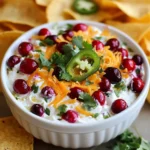 - 1 cup fresh or frozen cranberries - 1-2 jalapeños, finely chopped (remove seeds for a milder flavor) - 1/2 cup cream cheese, softened to room temperature - 1/2 cup sour cream - 1/2 cup shredded sharp cheddar cheese - 1 tablespoon honey - 1 tablespoon fresh lime juice - 1/4 teaspoon garlic powder - 1/4 teaspoon fine sea salt - 1/4 teaspoon freshly ground black pepper - Fresh cilantro leaves for garnish (optional) - Tortilla chips or warm pita bread for serving If you need to change the amounts, here are some simple conversions: - 1 cup = 8 fluid ounces - 1 tablespoon = 3 teaspoons - 1/2 cup = 4 fluid ounces You can switch things up with these options: - Use Greek yogurt instead of sour cream for a tangy twist. - Try cream cheese with herbs for extra flavor. - If you like it spicy, add more jalapeños or a dash of hot sauce. - Swap fresh cranberries with canned ones for ease. {{ingredient_image_2}} Start with a medium saucepan. Add 1 cup of fresh or frozen cranberries and a splash of water. Turn the heat to medium. Cook for about 5-7 minutes. Stir occasionally as the cranberries pop and soften. You want them to burst open. After they soften, add 1-2 finely chopped jalapeños. If you want less heat, remove the seeds. Cook for another 2-3 minutes until the jalapeños soften. After that, take the pan off the heat and let it cool for a few minutes. Grab a large mixing bowl. Add 1/2 cup of softened cream cheese. Use an electric mixer or a sturdy spatula. Beat the cream cheese until it’s smooth and creamy. Then, add 1/2 cup of sour cream, 1/2 cup of shredded sharp cheddar cheese, and 1 tablespoon of honey. Squeeze in 1 tablespoon of fresh lime juice. Next, sprinkle in 1/4 teaspoon of garlic powder, sea salt, and black pepper. Mix everything well until it’s creamy and smooth. Now, gently fold the cooled cranberry and jalapeño mix into the cream cheese mixture. Make sure it’s evenly mixed throughout. Once combined, transfer the dip to a nice serving bowl. If you like, you can garnish it with fresh cilantro leaves. This adds a nice touch and extra flavor. Serve right away with tortilla chips or warm pita bread for dipping. Enjoy! To get the best texture for your dip, start with softened cream cheese. This makes mixing easier. Use an electric mixer or a sturdy spatula to blend it until smooth. When adding the cooled cranberry mixture, fold it in gently. This keeps your dip creamy and avoids lumps. If you want your dip to be milder, remove the seeds from the jalapeños. This simple step makes a big difference. For more heat, leave some seeds in or add an extra jalapeño. You can also use a dash of hot sauce for an extra kick. Serve this dip with tortilla chips or warm pita bread. Both options are great for scooping. You can also offer it with fresh veggies like bell peppers or cucumbers. Garnish with fresh cilantro for added color and flavor. This dip is perfect for parties or game days! Pro Tips Use Fresh Ingredients: Whenever possible, opt for fresh cranberries and jalapeños to enhance the flavor of your dip. Fresh ingredients often provide a brighter taste compared to frozen ones. Adjusting Spice Levels: If you prefer a milder dip, remove all the seeds and membranes from the jalapeños. For more heat, leave some seeds in or add an extra jalapeño. Make Ahead: This dip can be prepared a day in advance. Store it in the refrigerator, and let it come to room temperature before serving for the best flavor and texture. Experiment with Cheese: While sharp cheddar is delicious, feel free to experiment with other cheese types such as pepper jack for added flavor or cream cheese for a creamier texture. {{image_4}} You can easily change this dip to suit your taste. If you want it sweeter, add more honey. For a creamier dip, use more cream cheese. You can swap some cheddar for mozzarella for a different flavor. If you like a crunch, mix in some chopped nuts like pecans or walnuts. You can also add bell peppers for extra color and crunch. To enhance the flavor, try adding spices. A pinch of cumin can give it a warm taste. A splash of hot sauce can add more heat if you like spicy food. Fresh herbs like basil or dill can change the flavor profile nicely. You could even mix in some roasted garlic for a deeper flavor. You can serve this dip in many ways. Try it with tortilla chips or warm pita bread. For a healthier option, use veggie sticks like carrots or celery. You can also spread it on toast for a tasty appetizer. For a fun twist, try it in a wrap with turkey or chicken. Each way brings out the flavors in a new light. To keep your leftover dip fresh, place it in an airtight container. Make sure the lid seals well. Store it in the fridge for up to three days. If you see any changes in color or smell, toss it out. You can freeze the dip if you want to save it longer. Use a freezer-safe container and leave some space at the top. This dip can last for up to three months in the freezer. When ready to use, thaw it in the fridge overnight. To reheat the dip, place it in a bowl and microwave in short bursts. Stir in between each burst to heat evenly. You can also heat it on the stove over low heat. Stir until warm, then serve with chips or bread. Enjoy the flavors again! You can serve this dip with many tasty options. I love using tortilla chips for crunch. Pita bread works well too. You can even try fresh veggies like carrots or celery sticks. They add a nice crunch and freshness. Yes, you can make this dip ahead of time! It tastes even better after chilling. Just cover it and place it in the fridge. It will stay good for up to two days. When you're ready to serve, just give it a quick stir. To make it spicier, add more jalapeños. You can keep the seeds for extra heat. For a milder dip, remove the seeds and use just one jalapeño. You can also add a bit of extra honey to balance the heat and sweetness. This guide walks you through making a delicious Cranberry Jalapeño Dip. We covered the key ingredients and their measurements. You learned step-by-step how to cook and mix everything together. I shared tips to get the best texture and serving suggestions for your dish. Don't forget the variations for custom flavors and how to store leftovers properly. Remember, cooking should be fun and tasty. Enjoy making this dip for your next gathering!